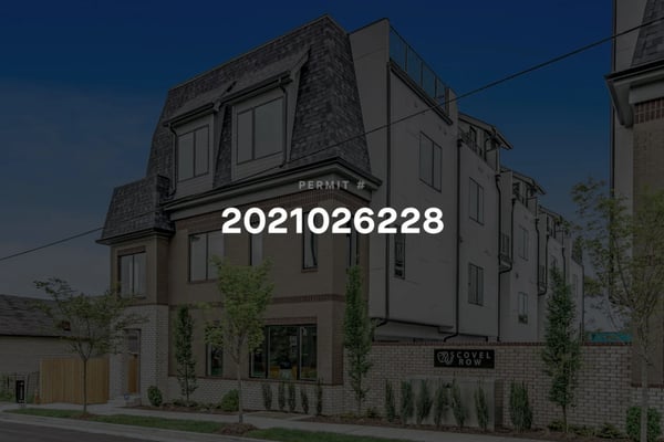 Modern brick townhouse with permit number 2021026228 displayed, dusk sky, landscaping with small trees